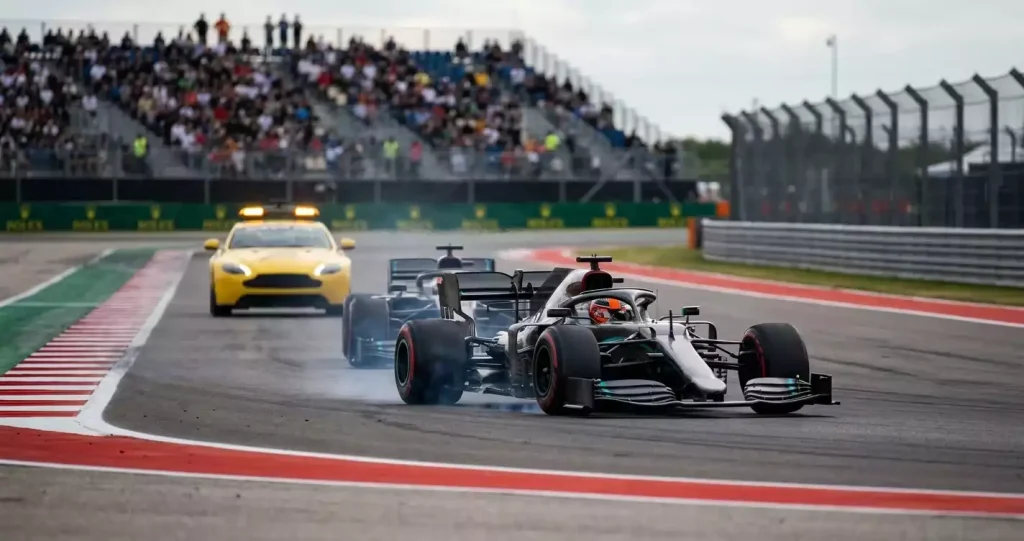 Formule&nbsp;1-wagens dicht achter elkaar tijdens een safety car-restart op een asfalt-racecircuit tijdens een Grand Prix-weekend