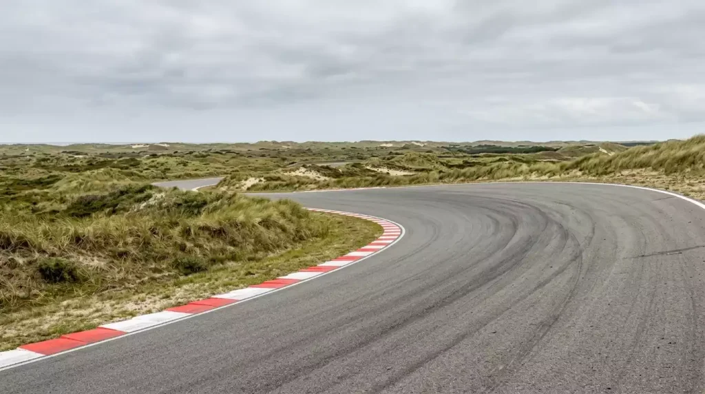 Banked corner van het circuit Zandvoort met duinlandschap aan de Noordzeekust